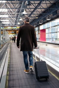 Rear view of man walking in airport