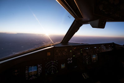 Airplane flying in sky seen through glass window