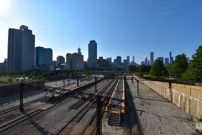 Railroad tracks in city against clear sky