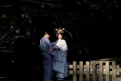 Man and woman standing by car on tree