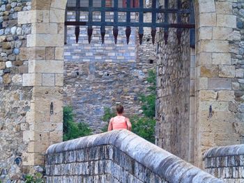 Rear view of woman standing at castle entrance