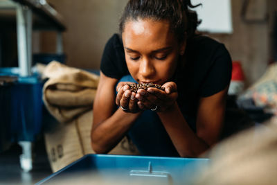 Midsection of woman holding while sitting on table at home