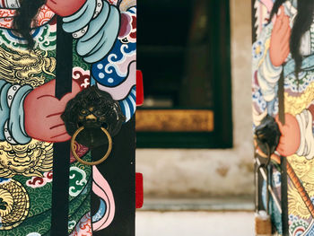 Midsection of woman holding painting standing against wall