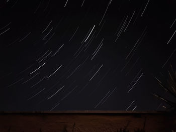 Low angle view of illuminated wall against sky at night