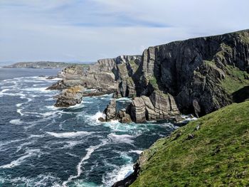 Rock formations by sea against sky