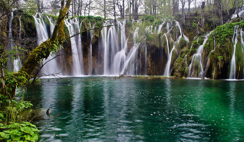 Scenic view of waterfall against sky