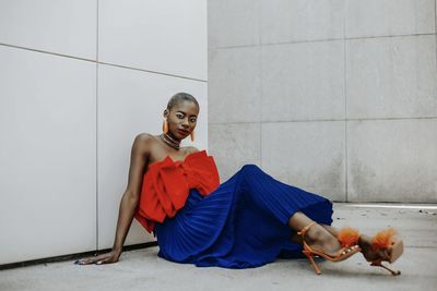 Portrait of young woman sitting on wall