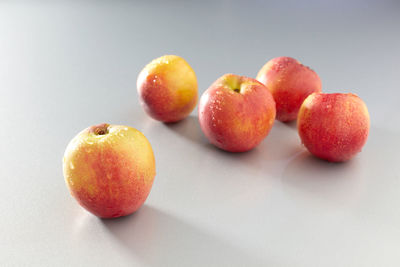 Close-up of apples on table against white background