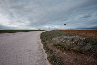 Road amidst field against sky