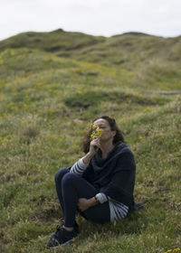 Full length of woman sitting on field