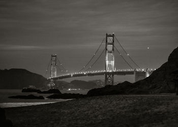 Suspension bridge over river at night