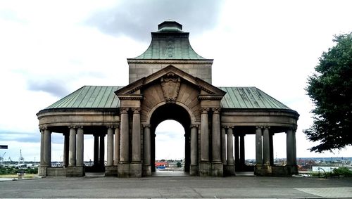 Architectural columns against cloudy sky