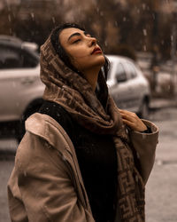 Portrait of young woman standing in city