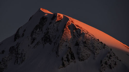 Scenic view of snowcapped mountains against sky during sunset