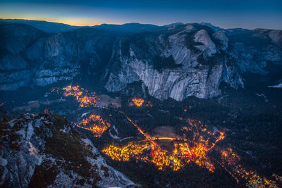 Aerial view of illuminated mountain range against sky