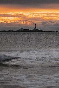 Scenic view of sea against orange sky