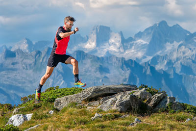 Full length of woman jumping on mountain