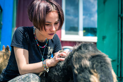 Close-up of boy playing with dog at home