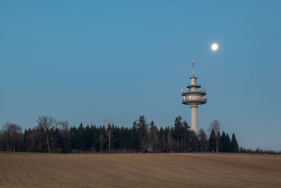 Scenic view of field against clear blue sky at dusk