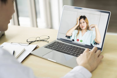 Midsection of businesswoman using laptop on table