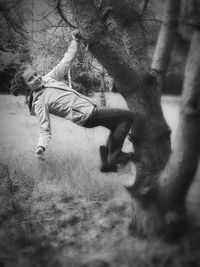 Man on tree trunk in field