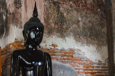 Statue against wall and building