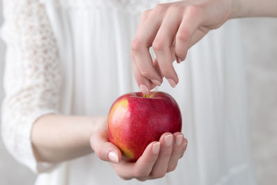 Midsection of woman holding apple