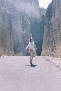 Full length side view of woman walking on mountain road