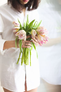 Midsection of woman holding flowers