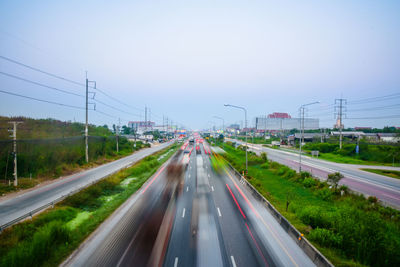 Traffic on road in city against clear sky