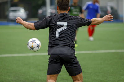 Rear view of soccer player playing field