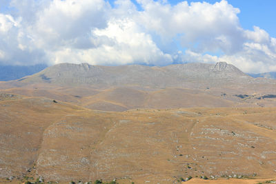 Scenic view of arid landscape against sky