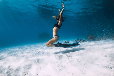 Low section of woman swimming in sea