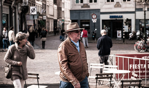 Rear view of people standing on street in city