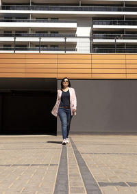 Rear view of young woman standing in city