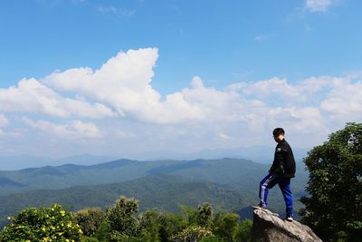 Man standing on mountain against sky