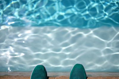 Low section of person swimming in pool