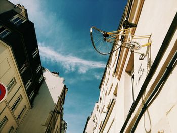 Low angle view of damaged bicycle mounted on building wall