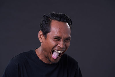 Portrait of young man against black background