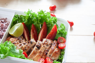 Meat and salad in bowl on table