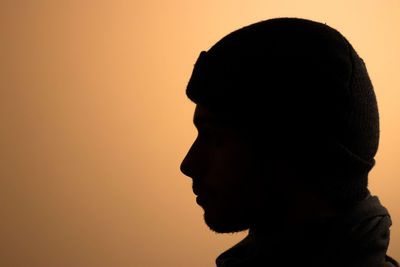 Close-up of silhouette man against orange sky