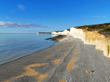 Scenic view of beach against blue sky