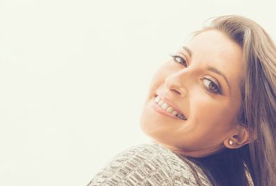 Portrait of smiling young woman against white background