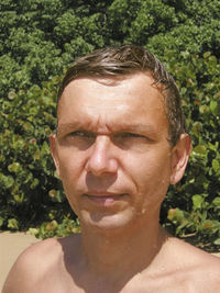 Close-up of wet man against plants