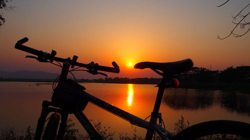 Silhouette bicycle against sky during sunset