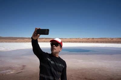 Man taking a selfie with the background of the andes mountain range