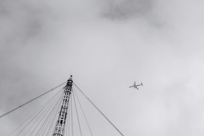 Low angle view of airplane flying over o2 arena