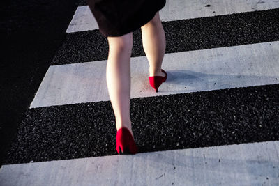 Low section of woman in red high heels