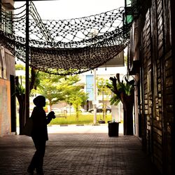Side view of man standing by buildings in city