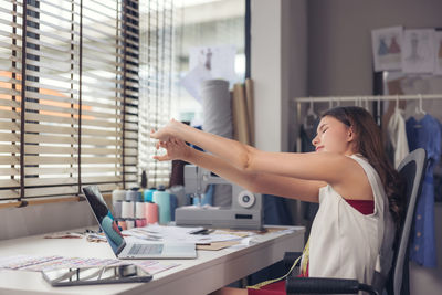 Side view of a woman working on table